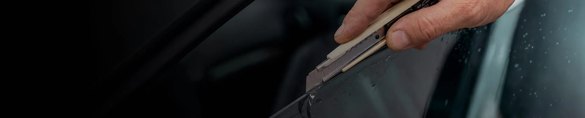 Homem passando estilete em película automotiva