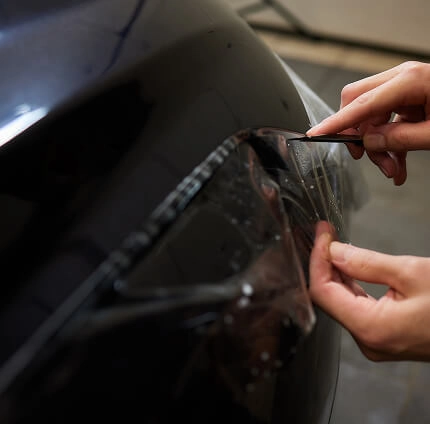 IMAGEM ILUSTRATIVA - HOMEM APLICANDO PELÍCULA EM CARRO
