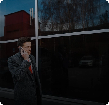 Homem falando ao telefone em frente a 4 vidros