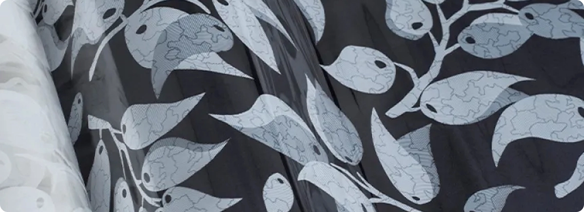 Ambiente moderno com janelas de vidro decoradas com a Película Decorativa Galhos, mostrando o padrão de galhos e folhas que traz leveza e movimento ao vidro